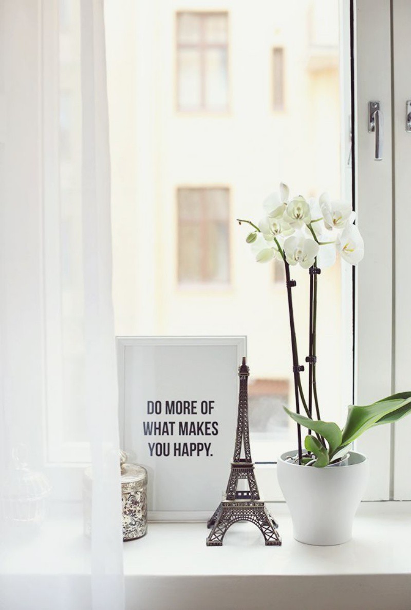 Một góc cửa sổ phòng khách được trang trí bằng cây hoa và đồ vật trang trí nhỏ xinh